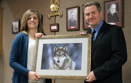 LINCOLN, CATHEDRAL - Joel Sartore of the Cathedral of the Risen Christ in Lincoln, a freelance photographer for National Geographic, presents a print to Laura Johnson, chair of the Cathedral School auction. The print is one of four that will be included among the auction items at the Feb. 1 event to support the school. (SNR photo by Cathy Blankenau Bender)